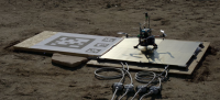 UAV platform for the experiment placed on the charging station next to fiducial markers for precision landing