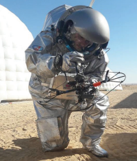 Analog astronaut holding a quadcopter, showing a possible surface exploration scenario